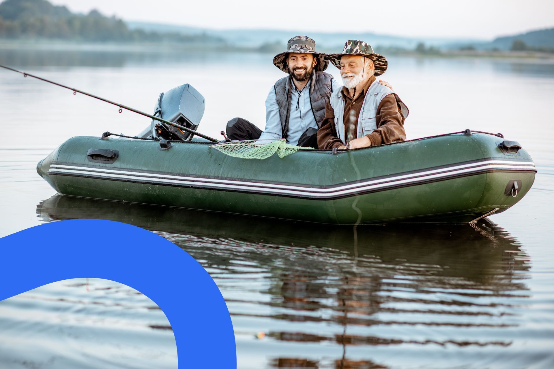 Deux hommes pêchent dans un bateau pneumatique vert sur une eau calme. L'un est plus âgé, l'autre plus jeune, tous deux portent un chapeau.
