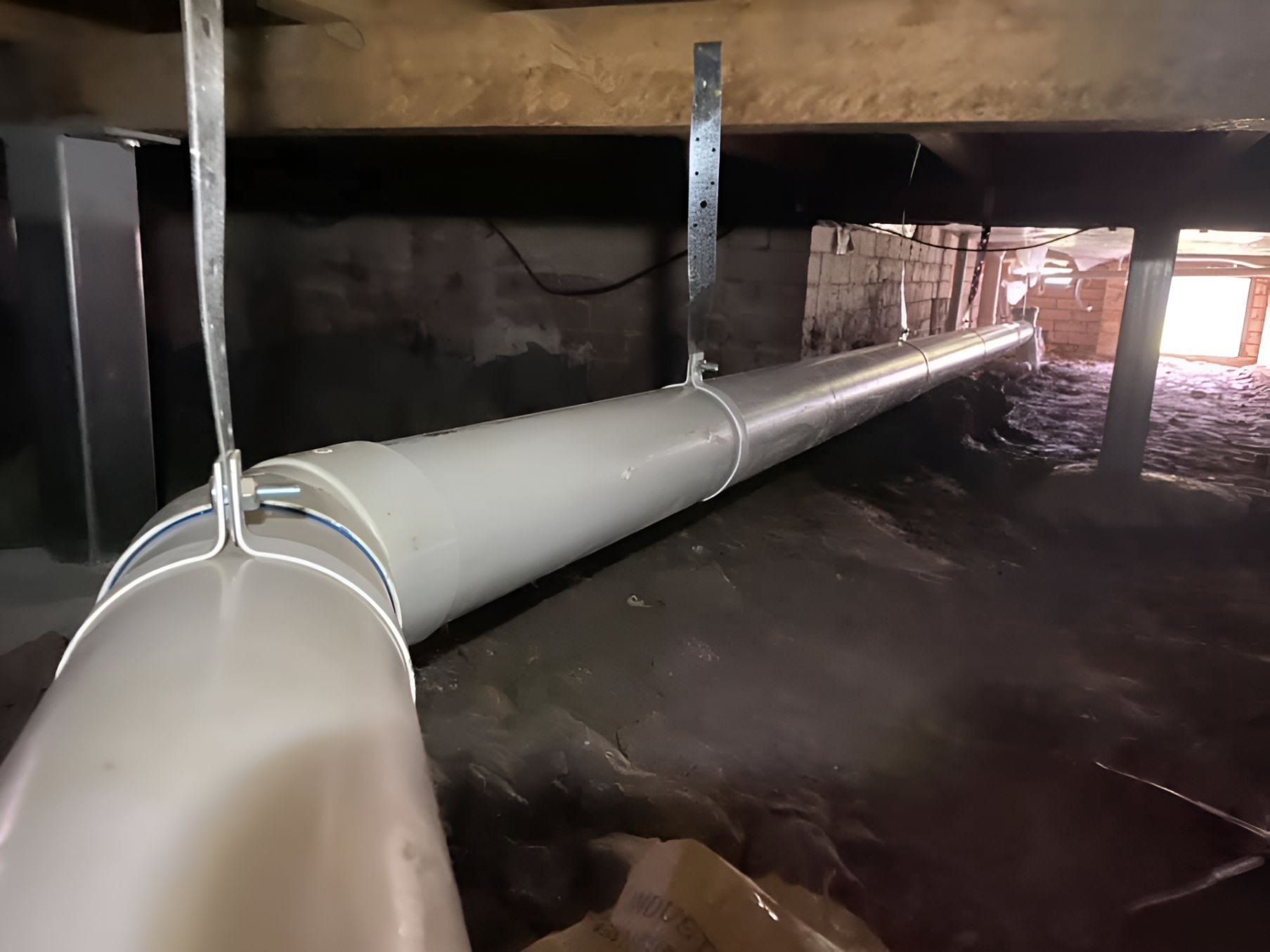 A White Pipe Is Hanging From The Ceiling In A Basement — Casino Plumbing In Casino, NSW