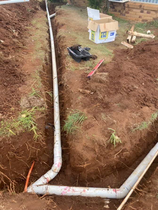 A Pipe Is Being Installed In A Trench In The Dirt — Casino Plumbing In Casino, NSW