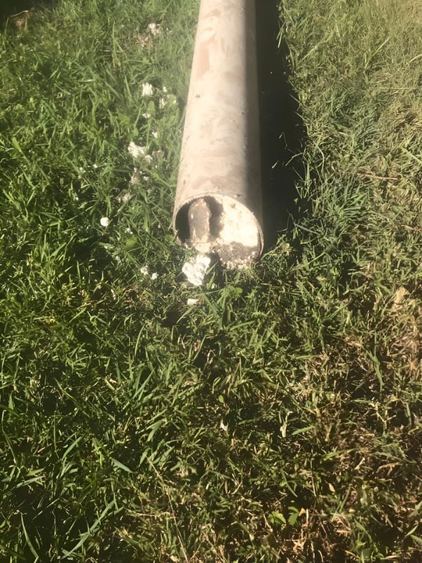 A Large Metal Pipe Is Sitting In The Grass — Casino Plumbing In Casino, NSW
