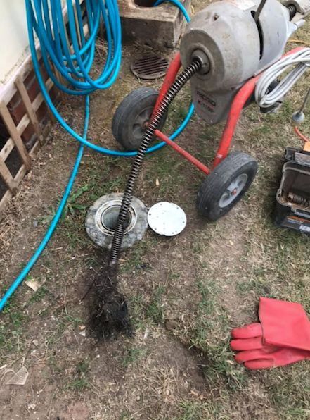A Drain Cleaner Is Sitting On The Ground Next To A Hose — Casino Plumbing In Casino, NSW