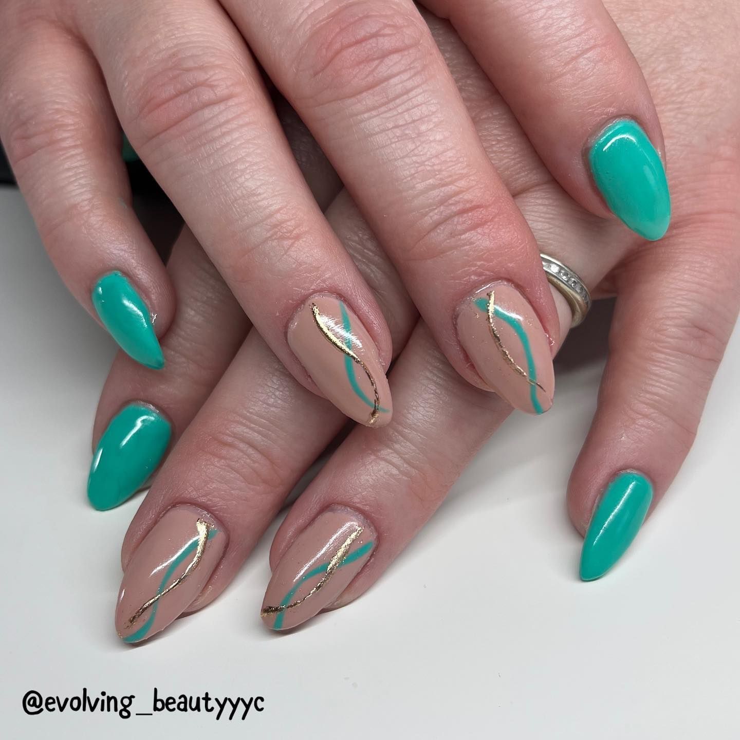 A close up of a woman 's nails with a ring on her finger