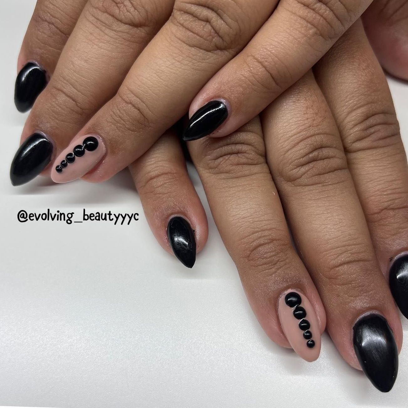 A close up of a woman 's hands with black nails