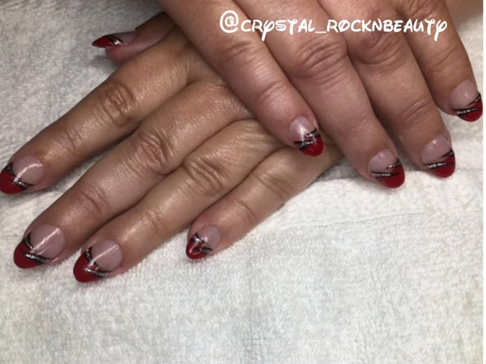 A close up of a woman 's nails with red french manicure