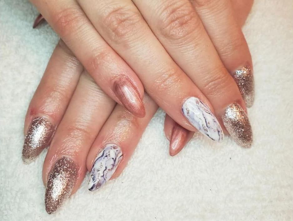 A close up of a woman 's nails with a marble design