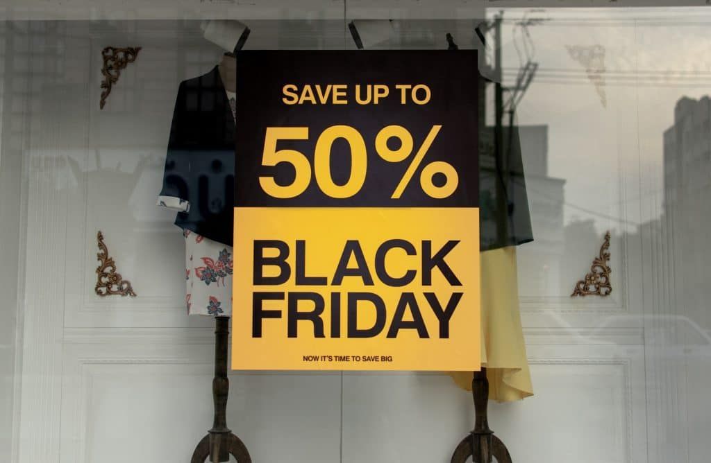 A sign in a store window says `` save up to 50 % black friday ''.