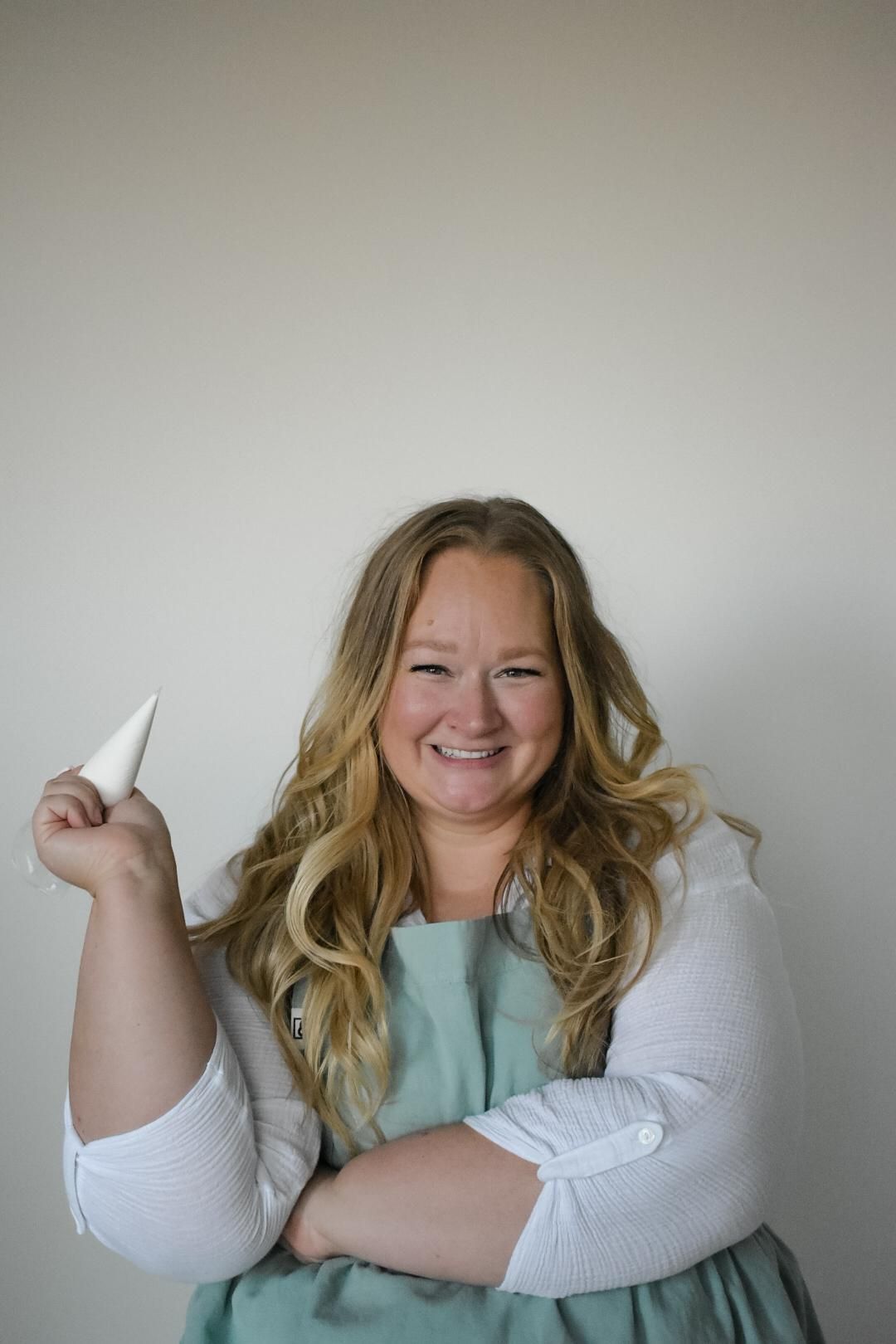 A baker in an apron holding a piping bag.