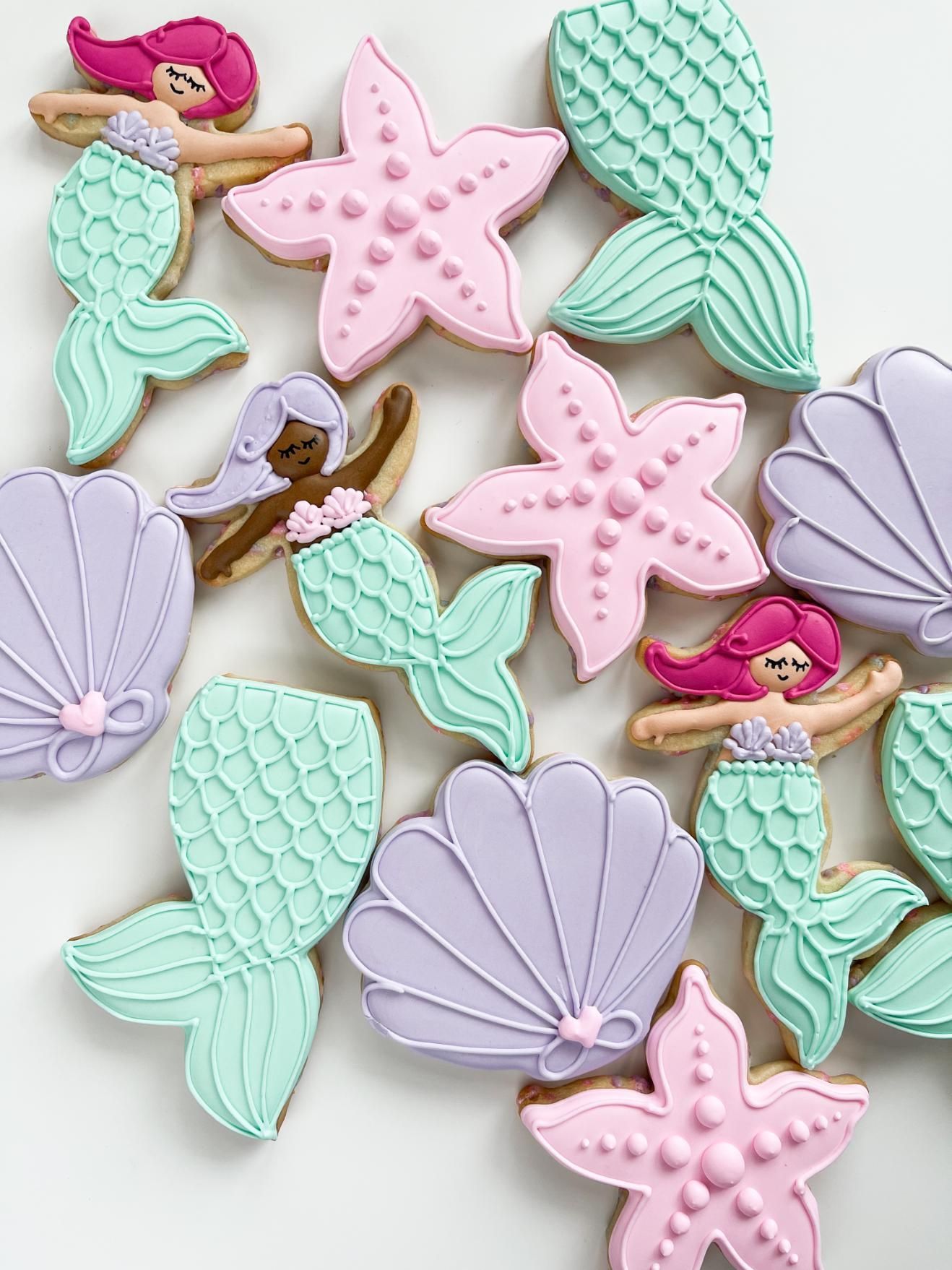 Mermaid cookies with sea shells and starfish in pastel colors.
