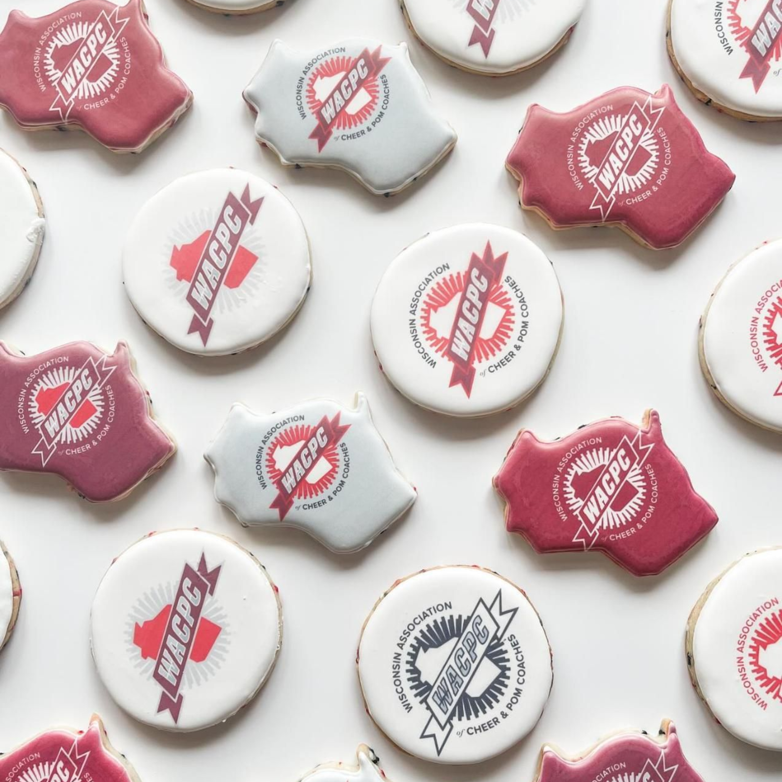 A variety of round and Wisconsin-shaped sugar cookies decorated with the red and white WACPC logo on a white background.