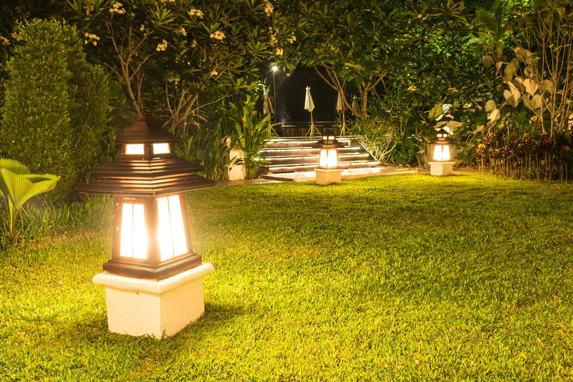 A lawn with a lantern in the middle of it at night.