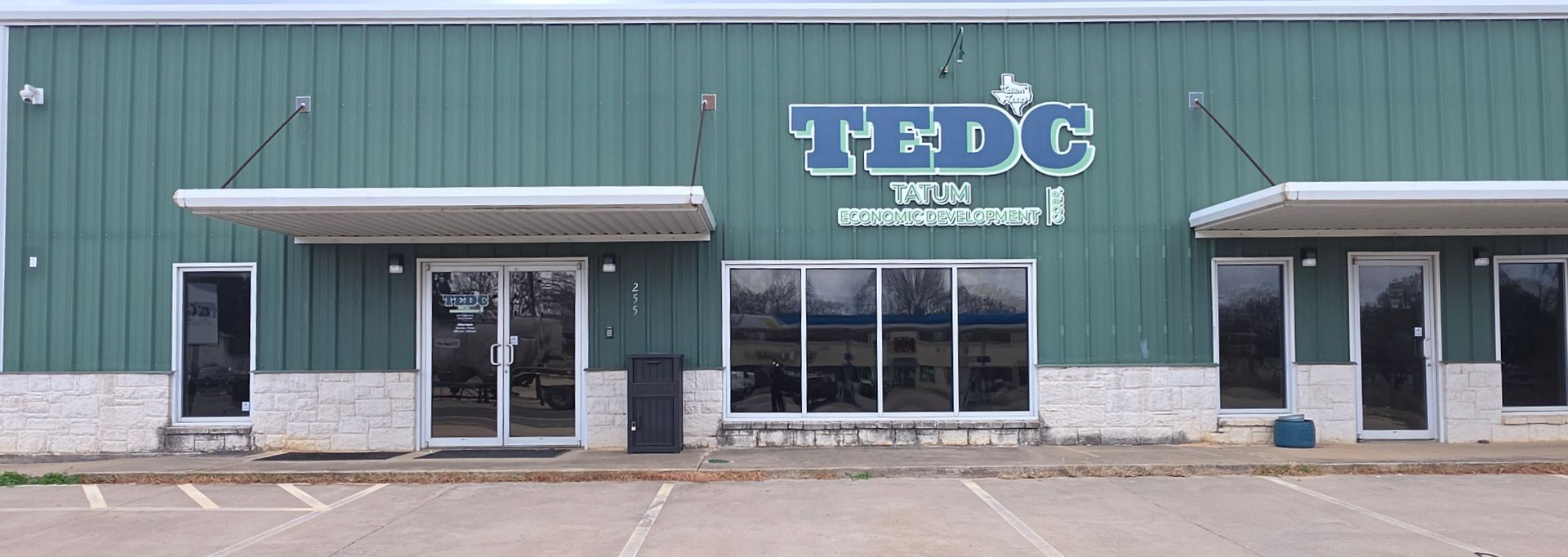A brick building with a gray roof and a white door