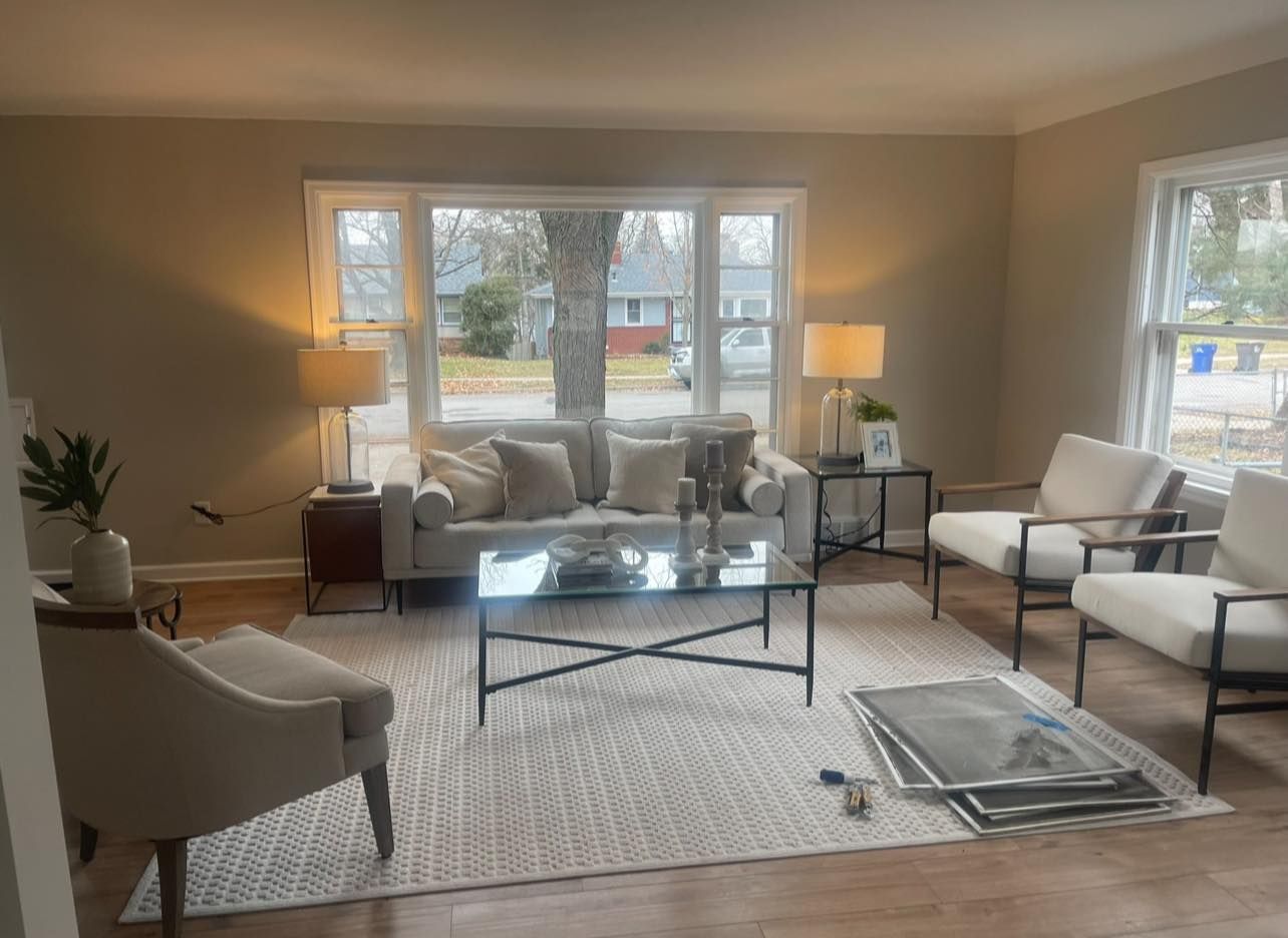 Living room with neutral color scheme, light-colored furniture, and a large window.