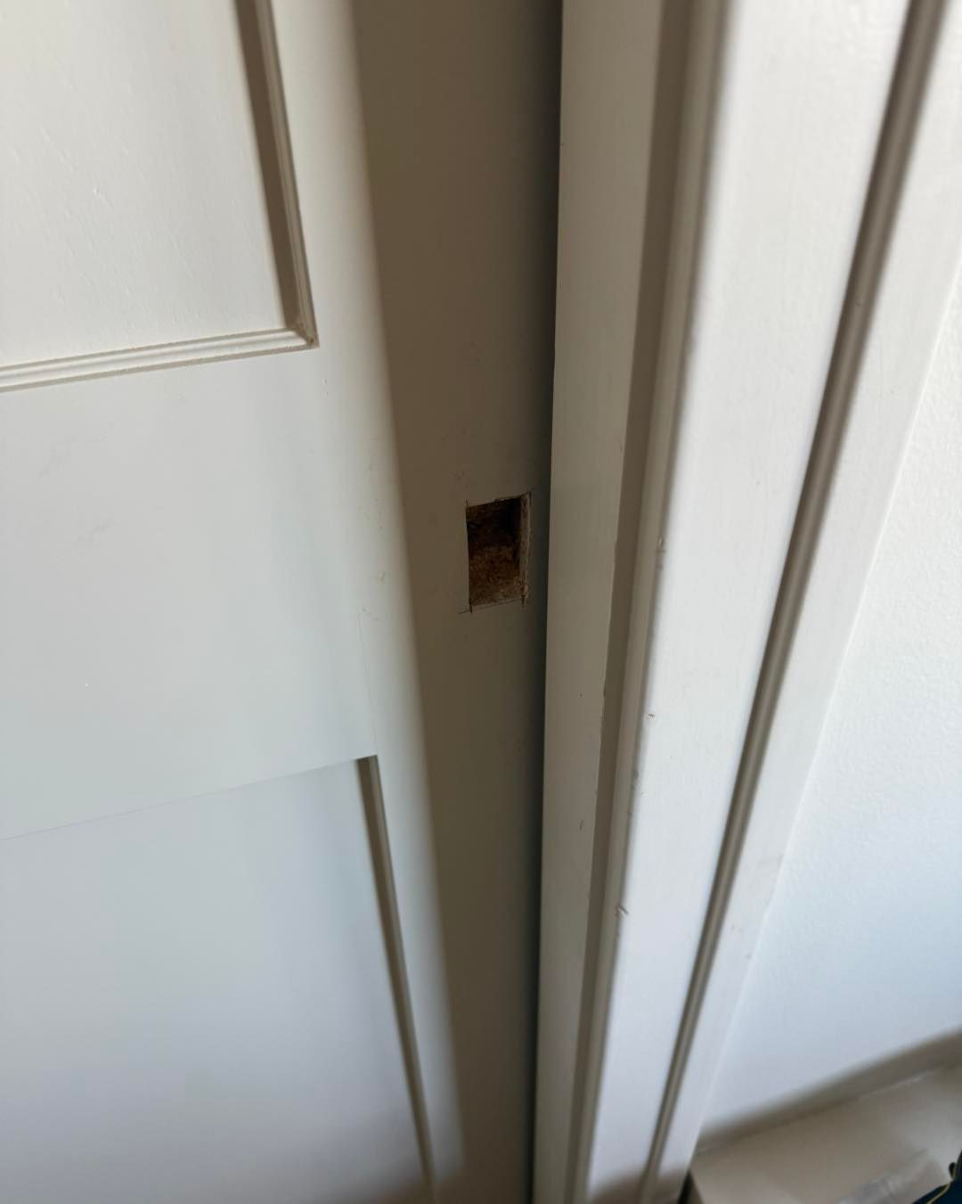 White door frame with a latch strike plate cutout.