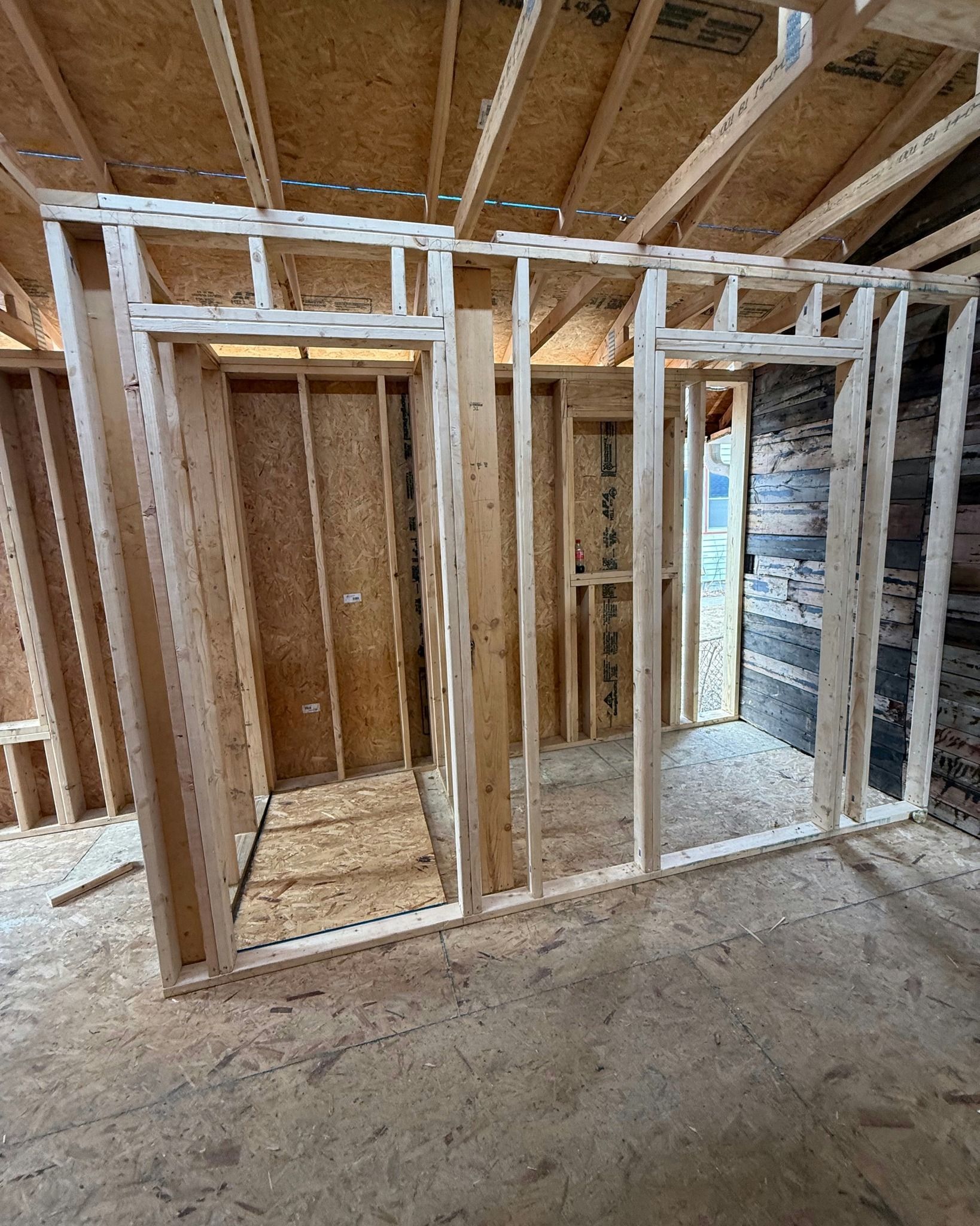 Interior view of a room under construction with wood framing for walls and doorways.