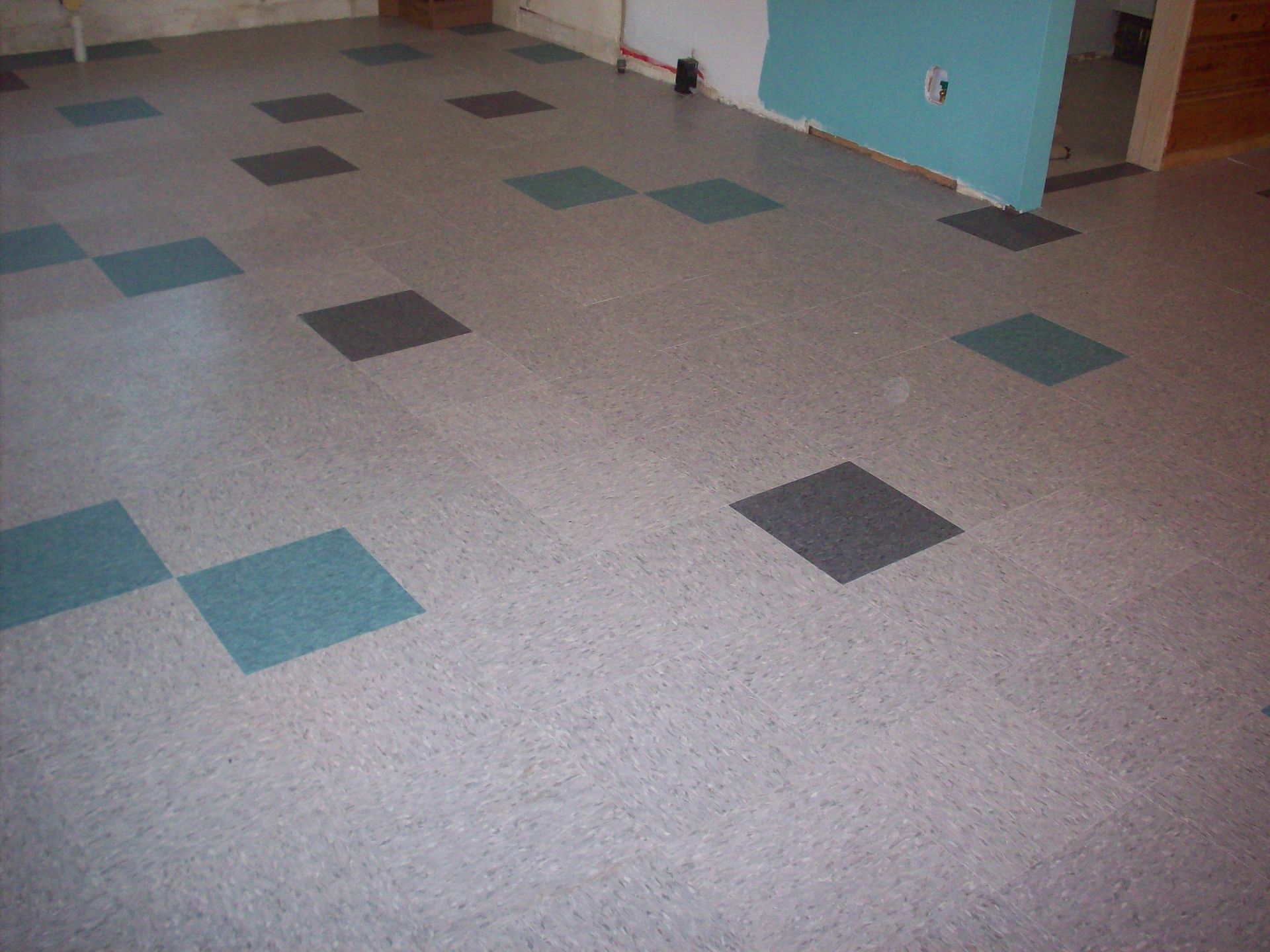 Grey floor with teal and dark grey square tiles. Interior view.
