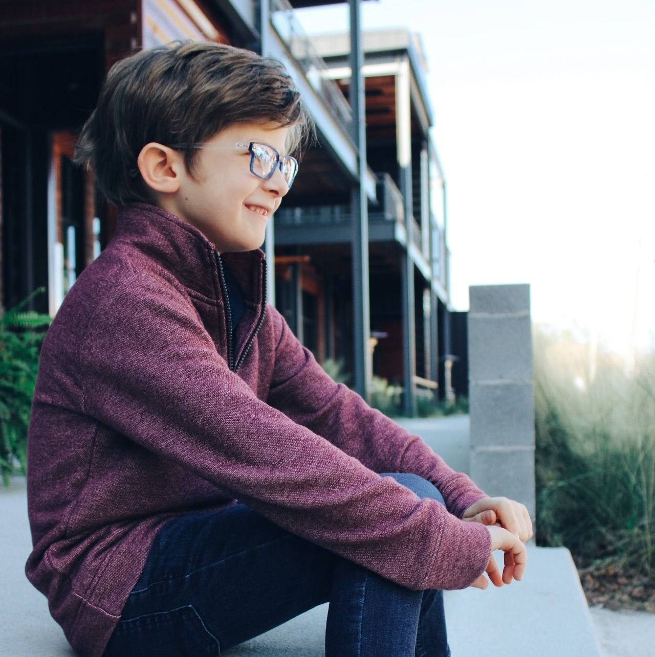exterior CustomEyes boutique eyewear and optician, young boy wearing glasses and looking off into distance your child's vision needs