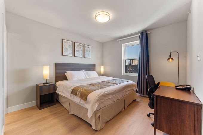 A hotel room with a bed and two lamps
