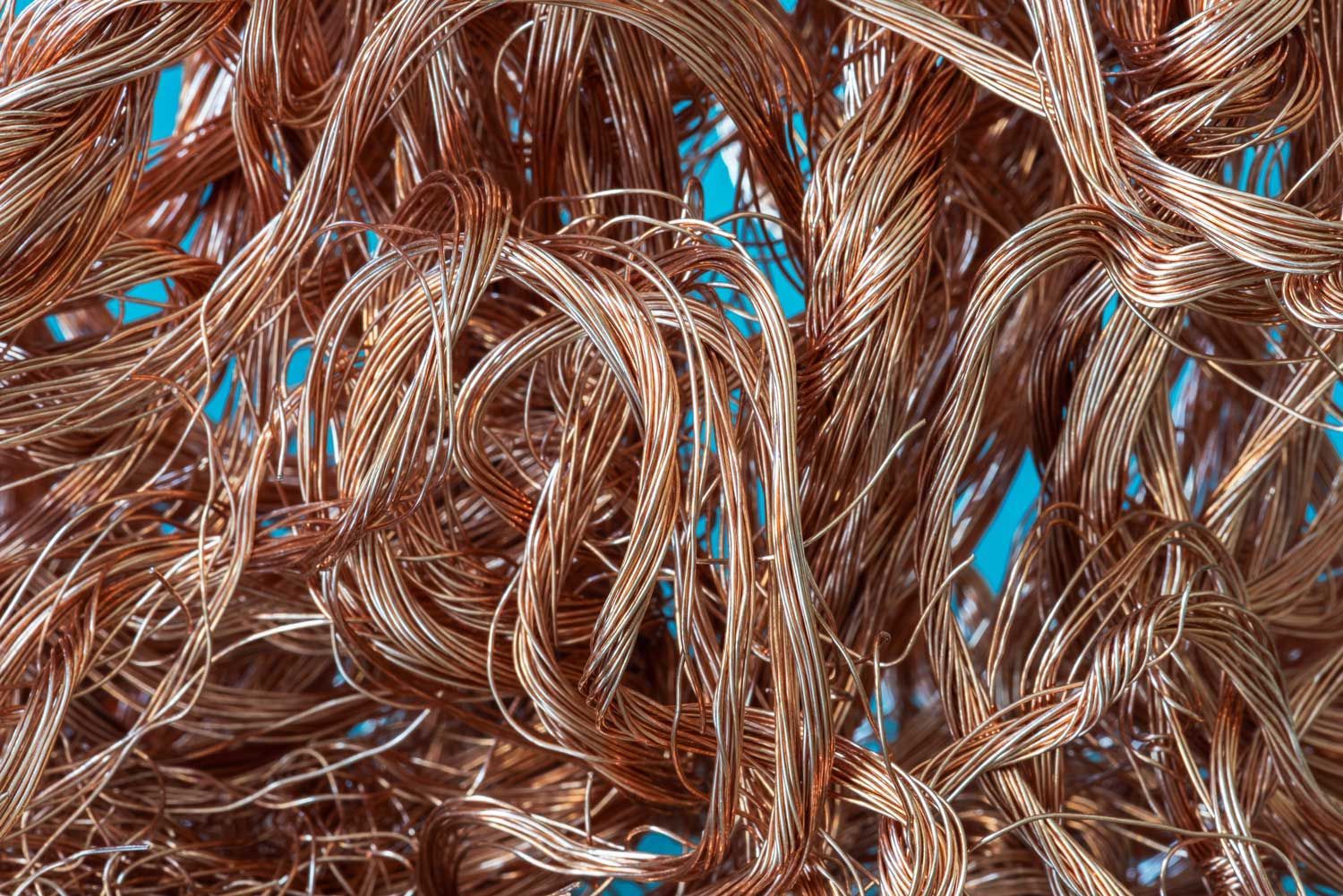 Copper wires coiled in a complex pattern with rich metallic texture.
