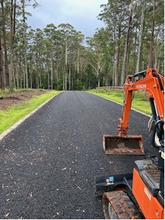 Digger on Road with Grass on Side of Road — Michael Flick Horticulture in Coffs Harbour, NSW