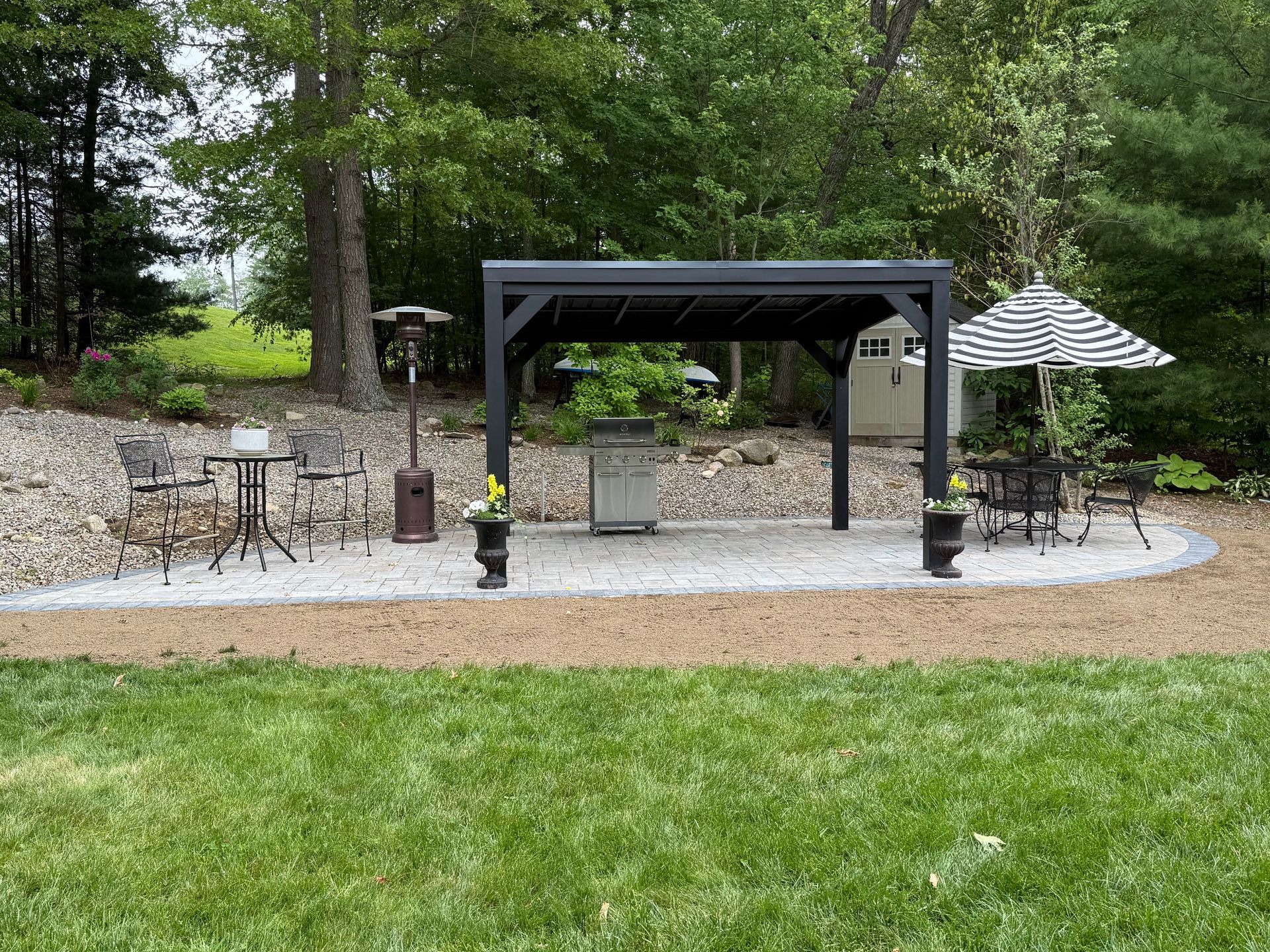 A table and chairs under an umbrella in a park.