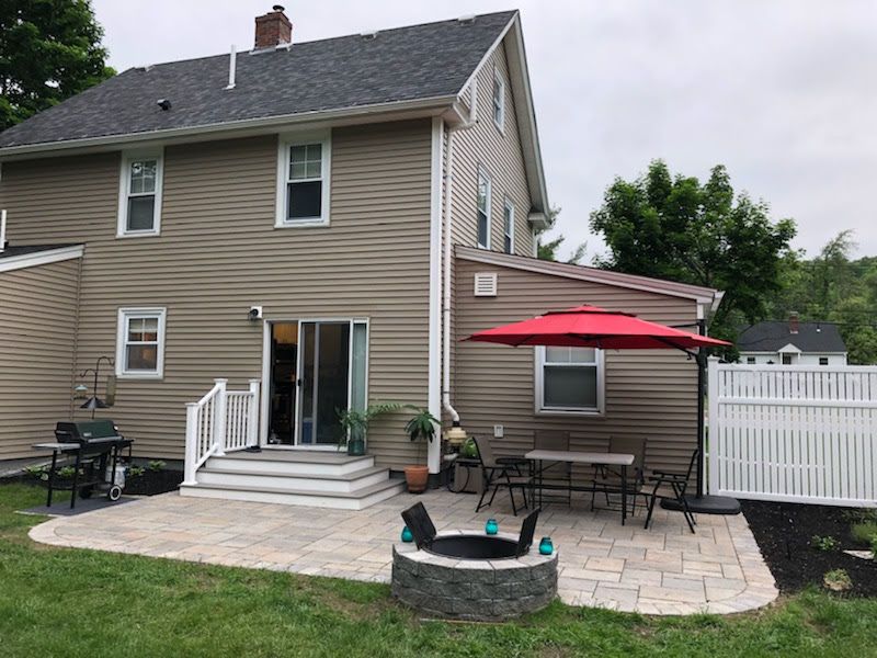 A house with a patio and a fire pit in front of it.