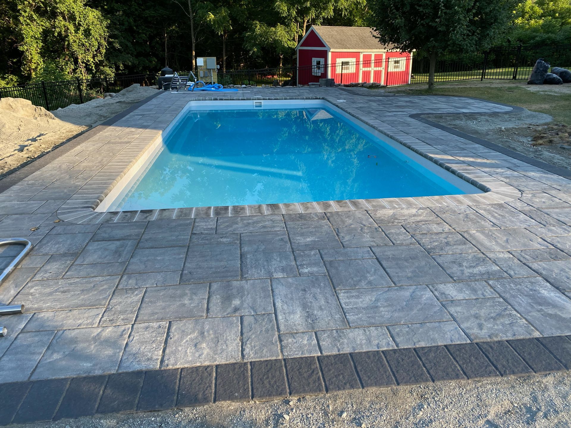 A large swimming pool with a red barn in the background