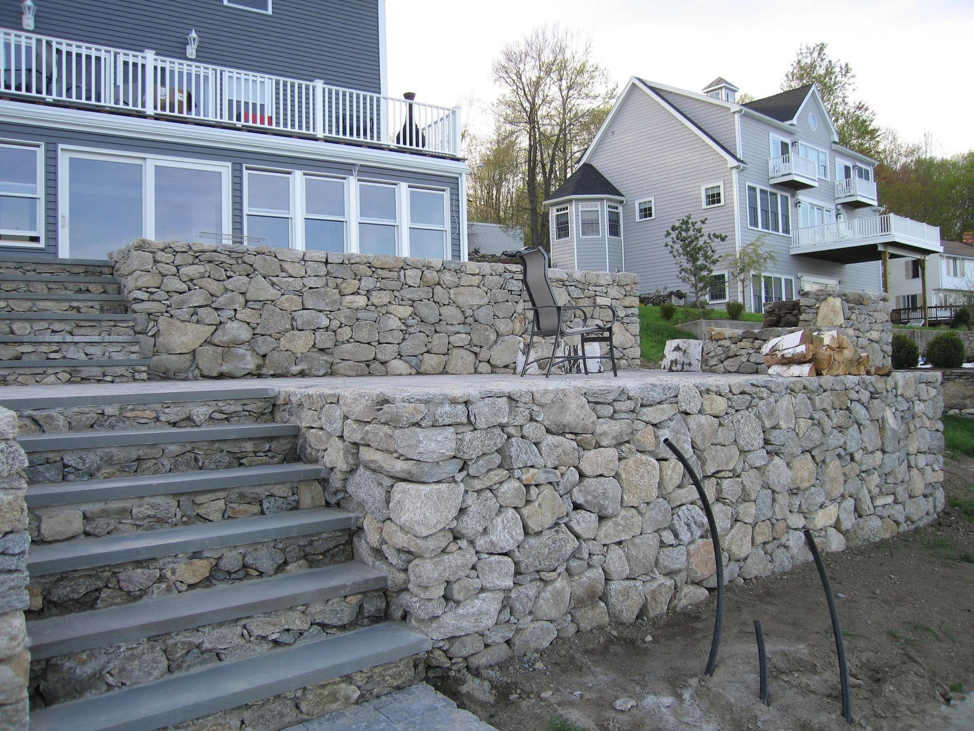 A stone wall with stairs leading up to a house