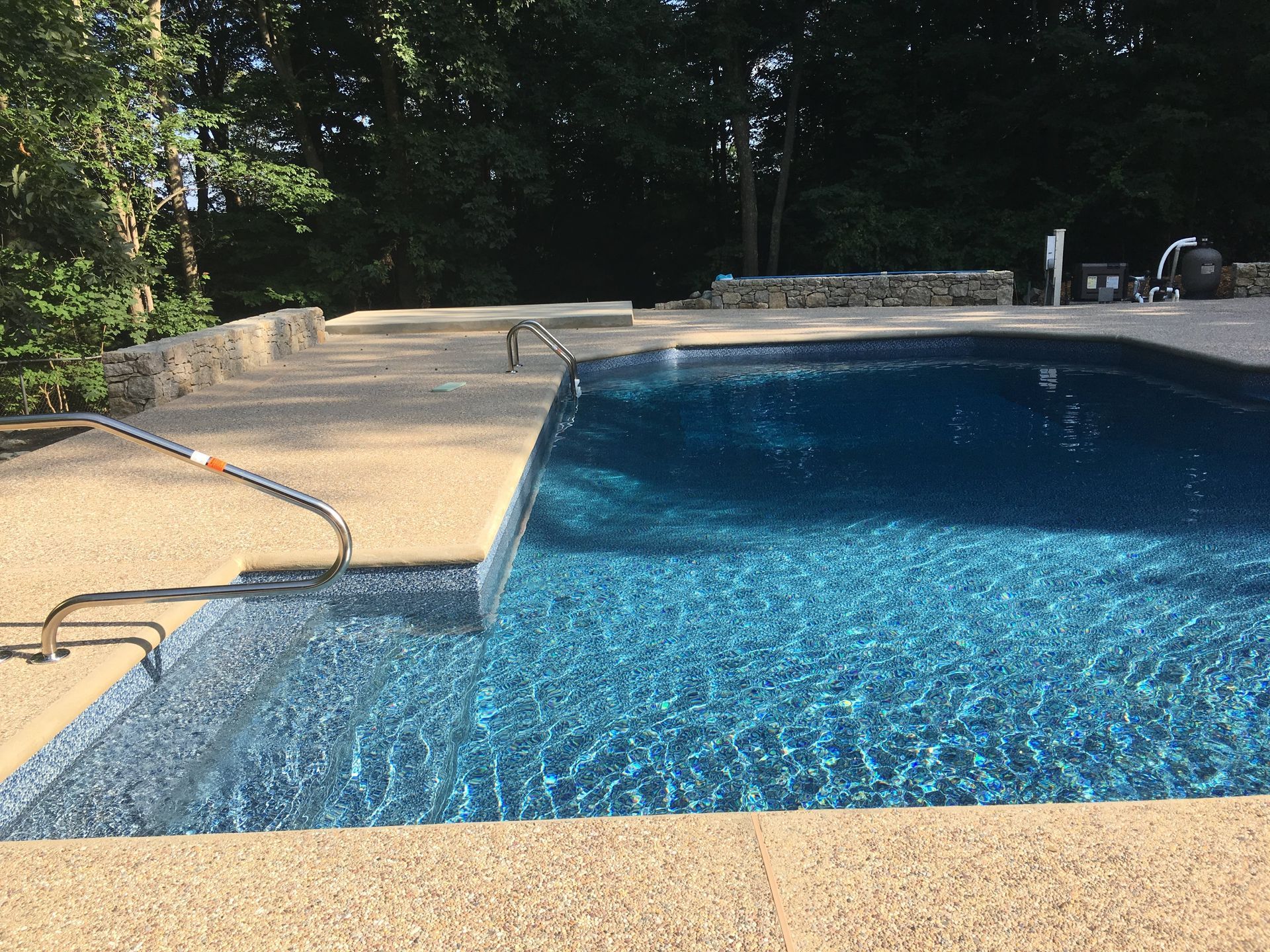 A large swimming pool with a hose attached to the side of it.