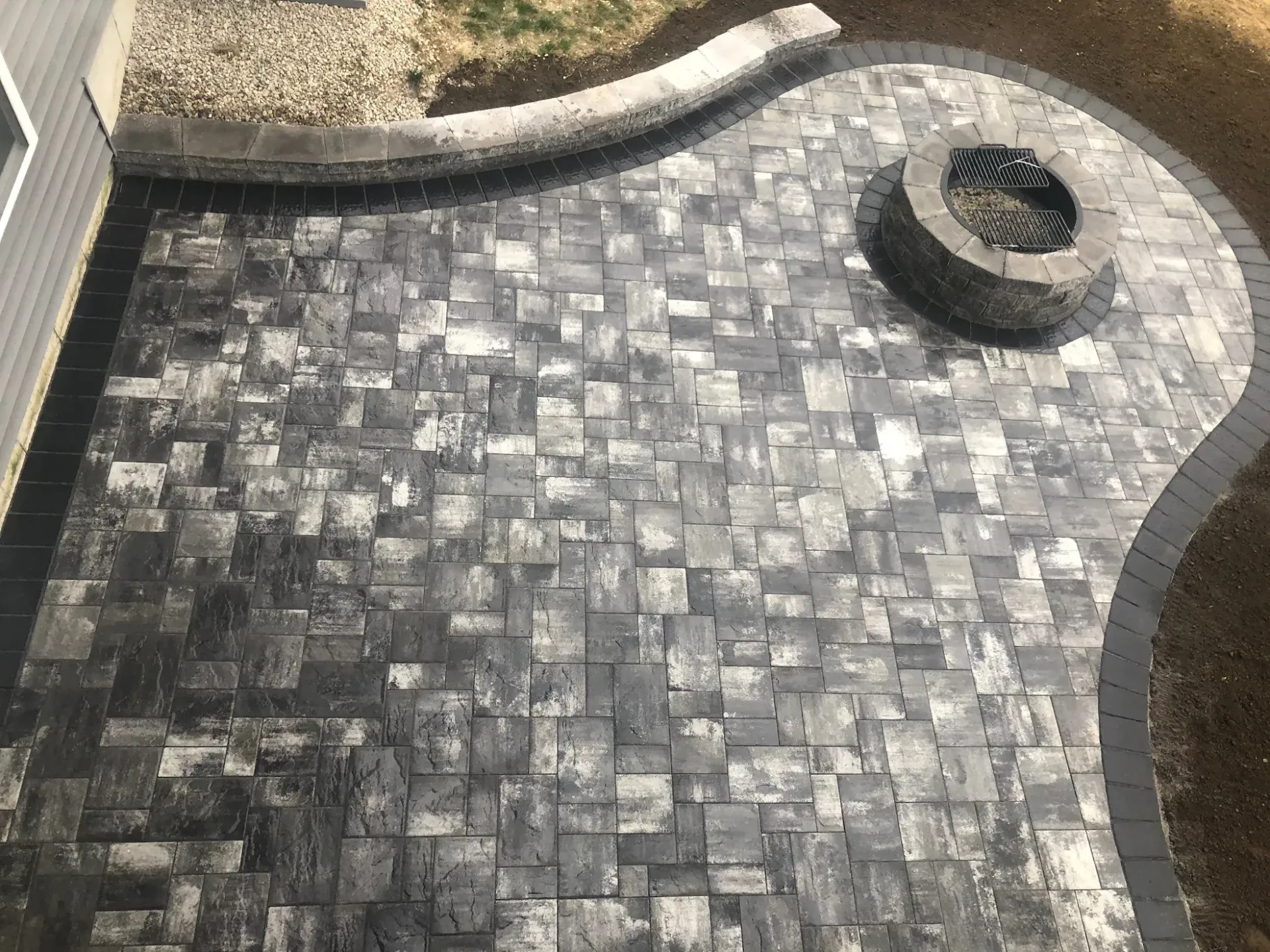 A patio with a fire pit in the middle of it.