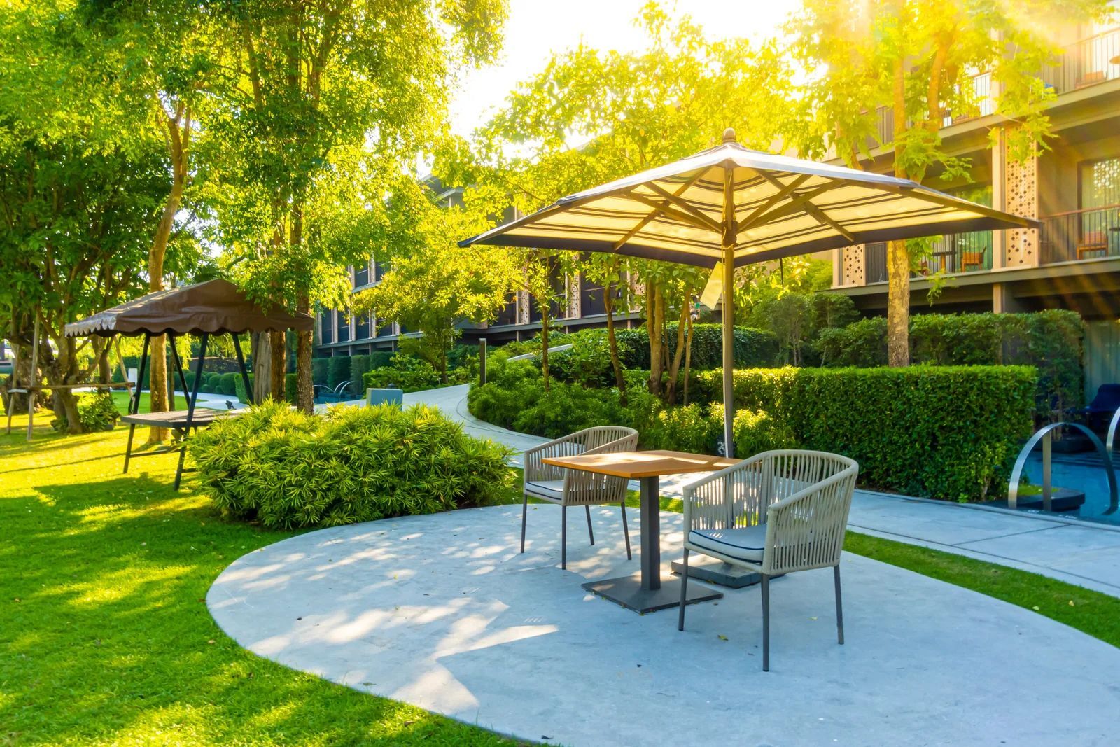 A table and chairs under an umbrella in a park.