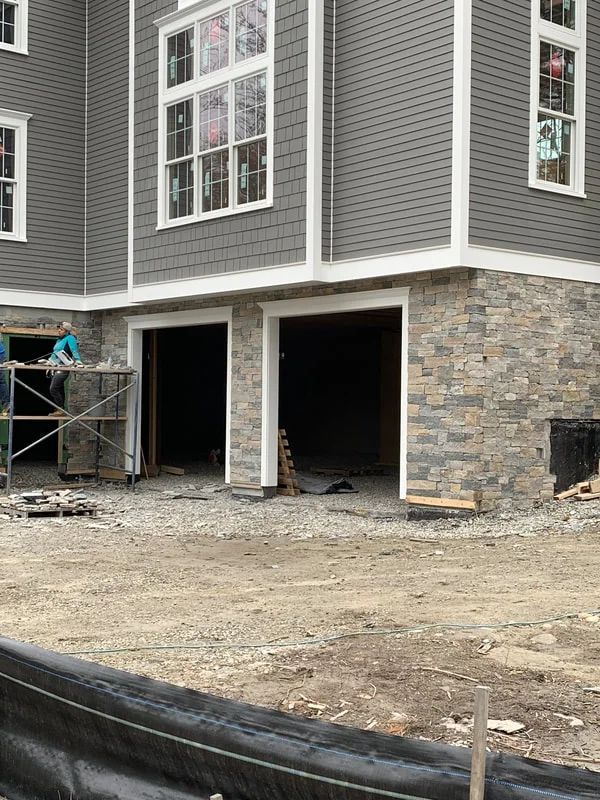 A house is being built with two garage doors open.