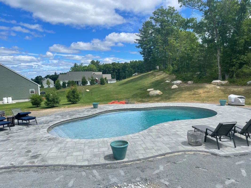 There is a large swimming pool in the backyard of a house.