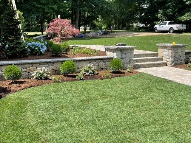 A white truck is parked in a driveway next to a lush green lawn.