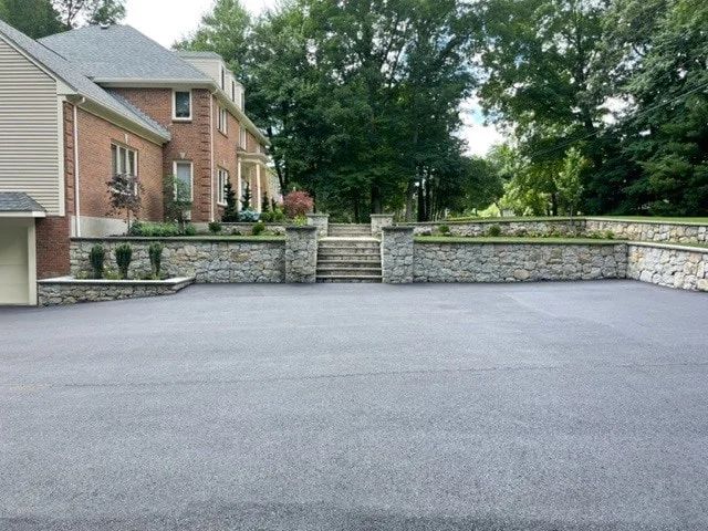 A large brick house with a large driveway in front of it