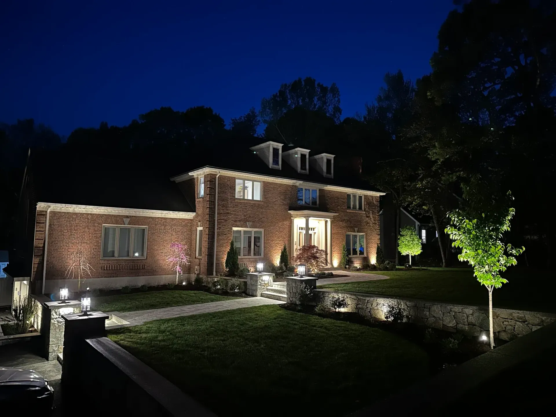 A large brick house is lit up at night
