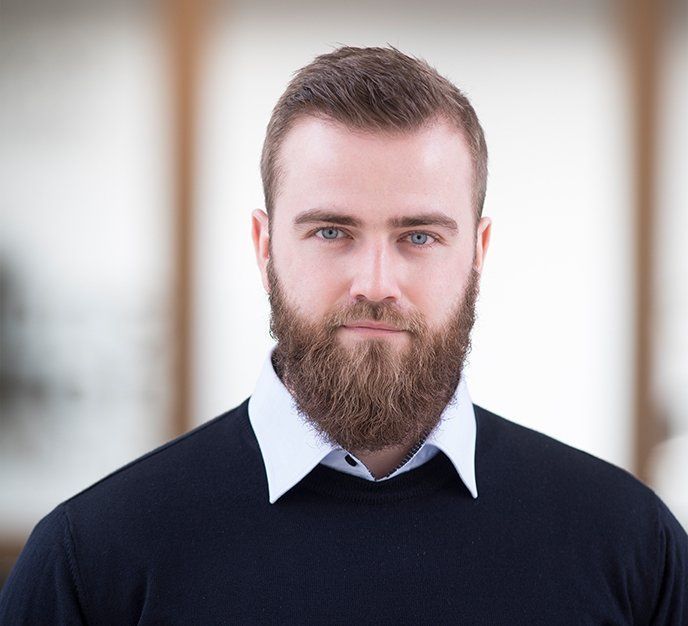 En mand med skæg er iført en sort sweater