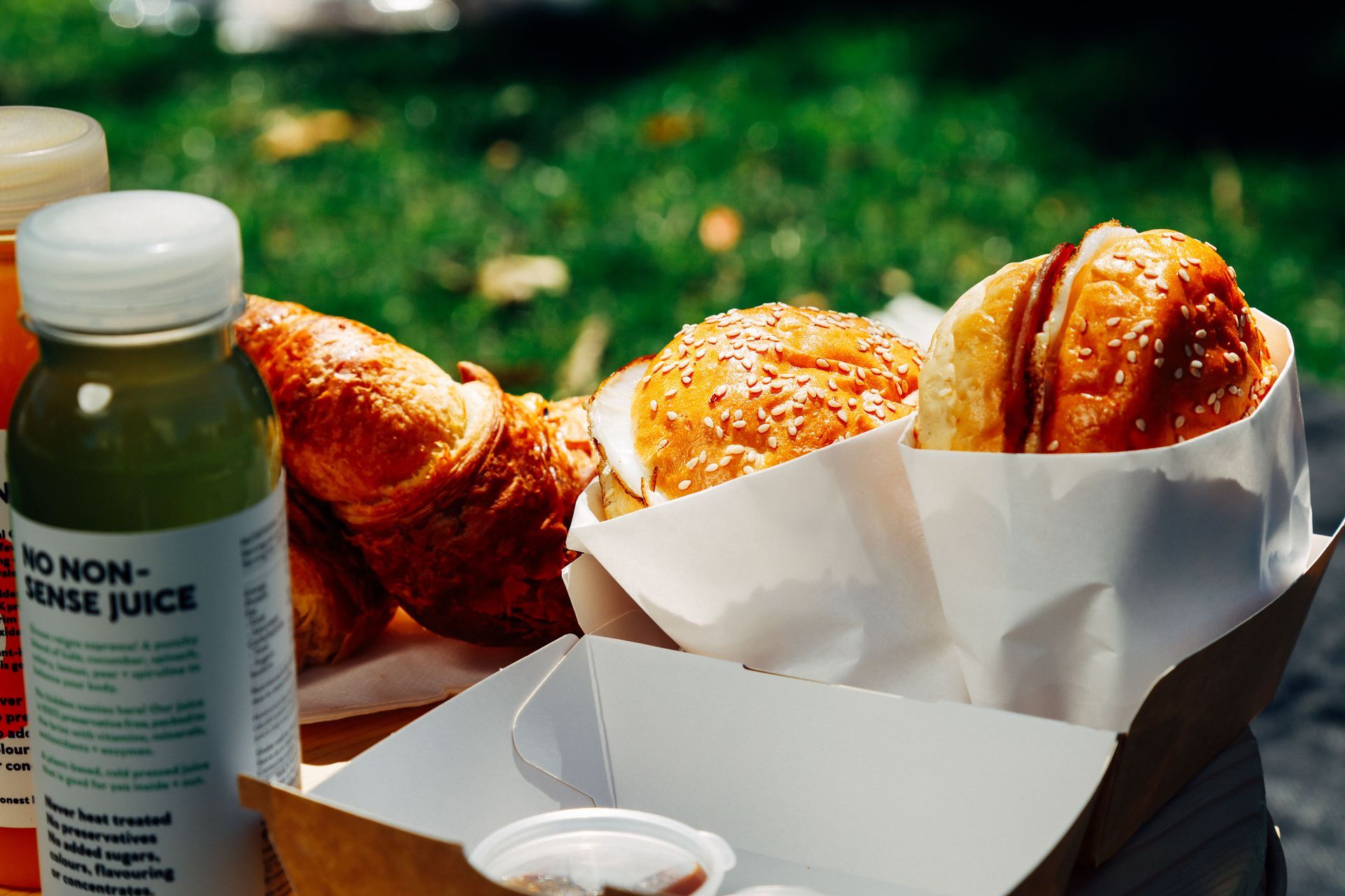 A bottle of no nonsense juice sits next to a basket of food