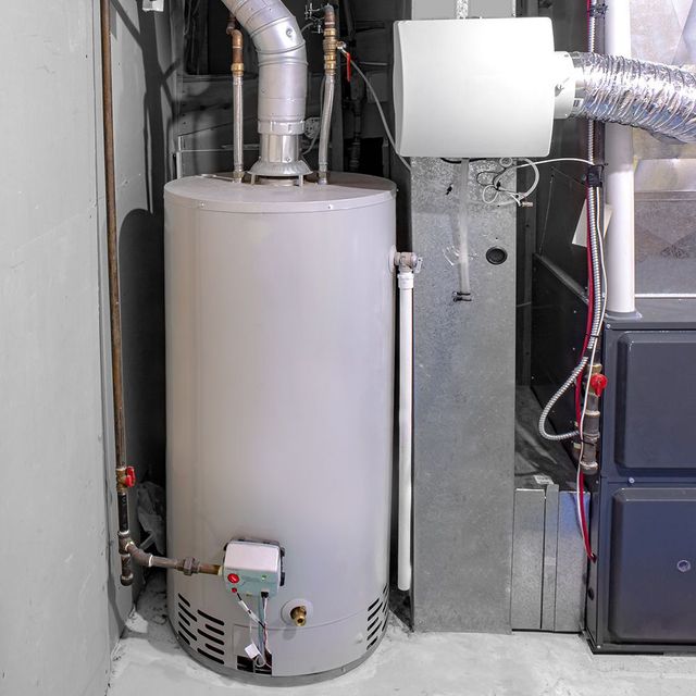 Water heater and furnace in a basement setting.