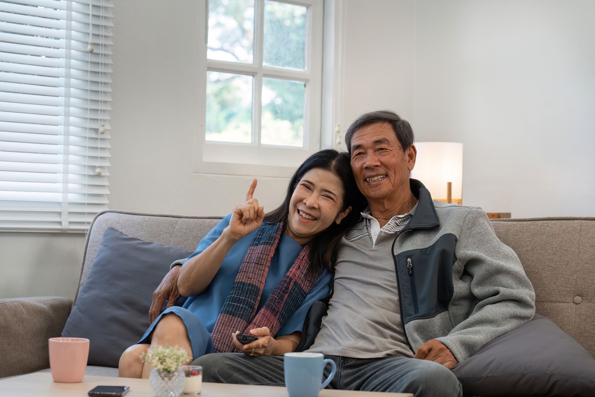 married seniors smiling while sitting on sofa