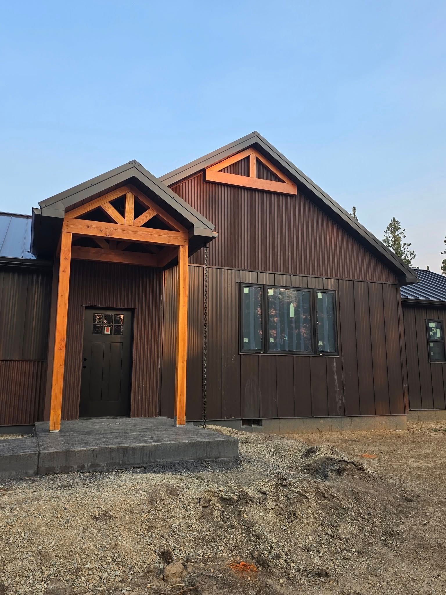 Brown house with a wooden porch and a triangular roof detail.