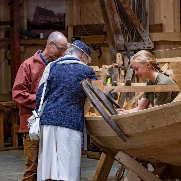 Dronning Magrethe på besøg i Forening for Traditionelle Håndværk. Står ved en træbåd under konstruktion.