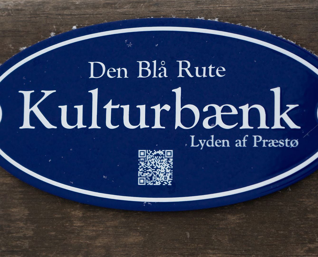 et blåt skilt, hvor der står Den Blå Rute Kulturbænk.