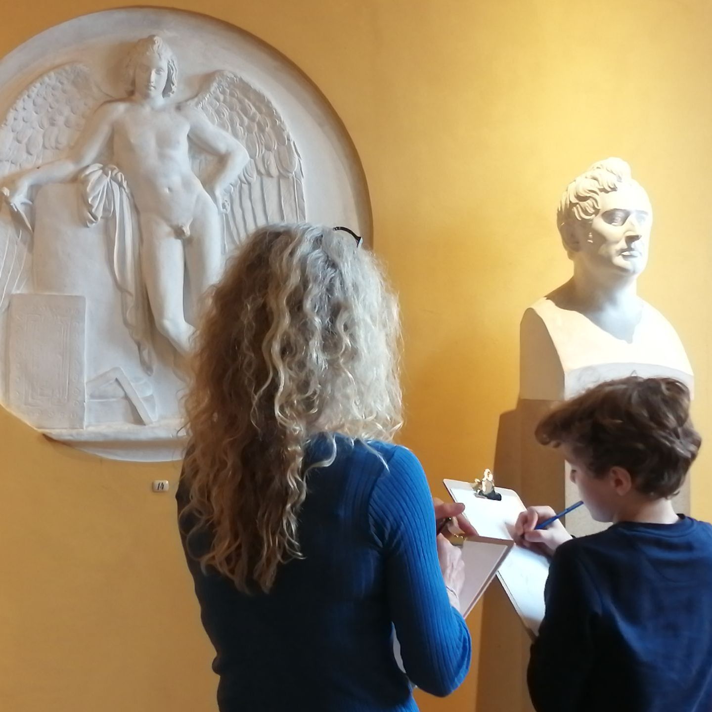 Kvinde og dreng tegner  et relief på Thorvaldsensamlingen