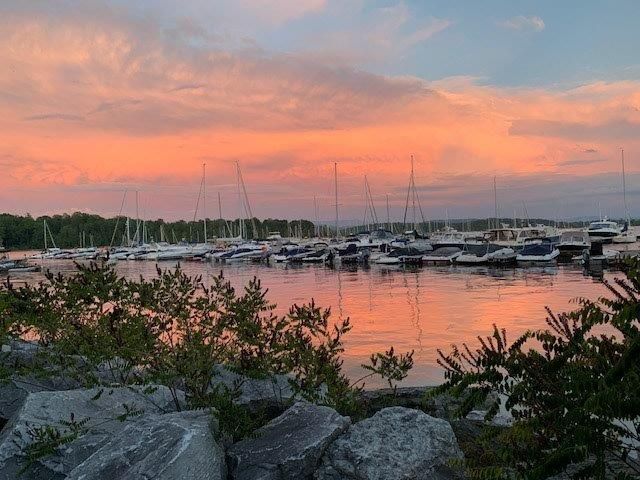 A sunset over a marina with boats docked in the water.