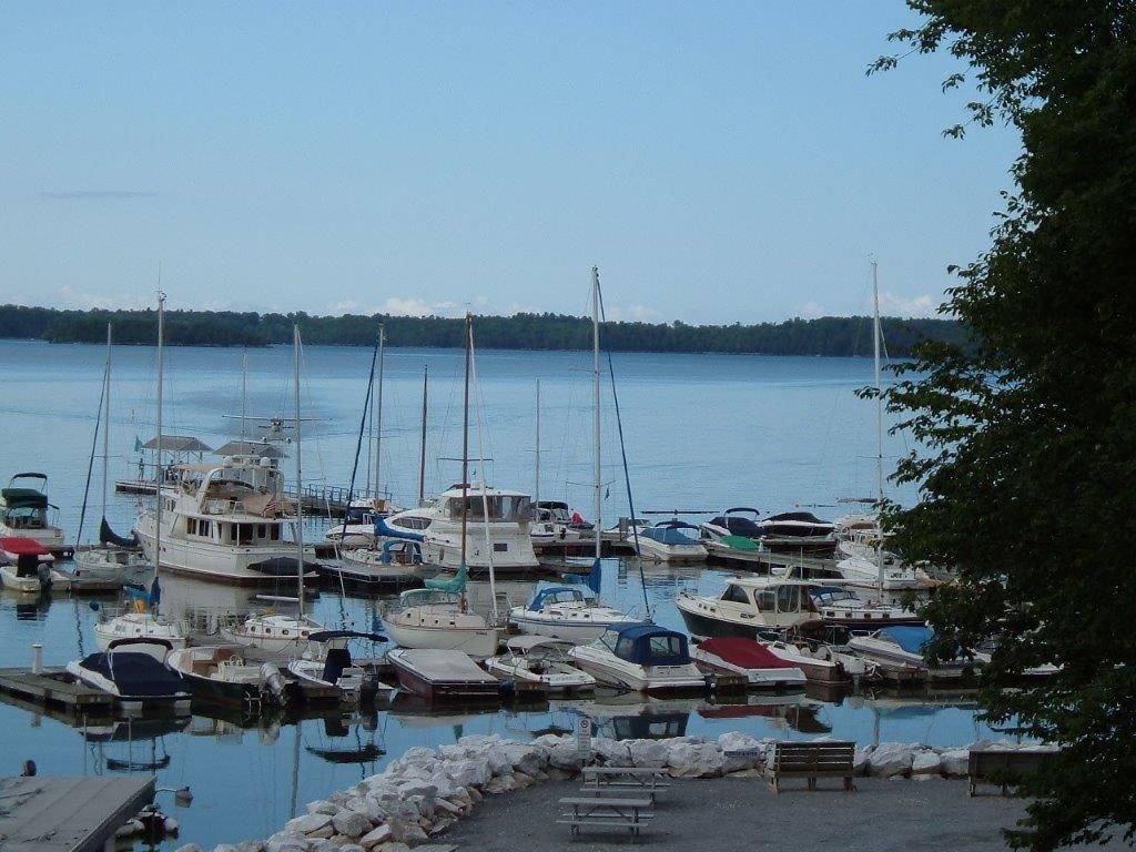Many boats are docked in a marina on a sunny day
