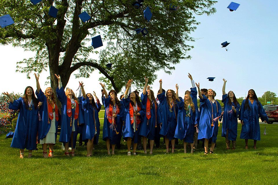 a group of graduates are throwing their caps in the air