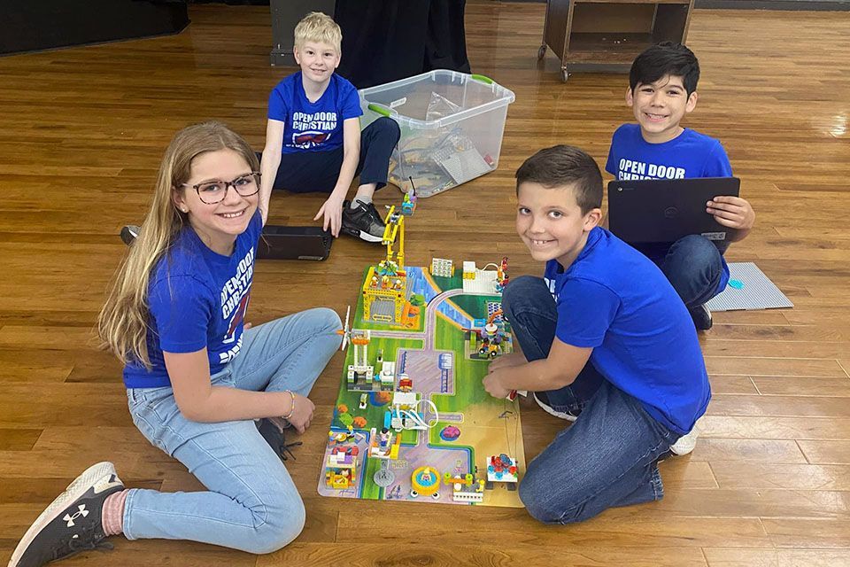 a group of children wearing blue shirts that say open door camp