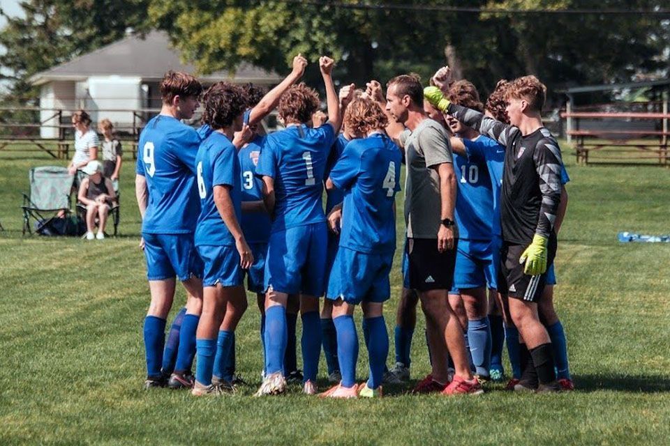 a group of soccer players huddle together with one wearing the number 10