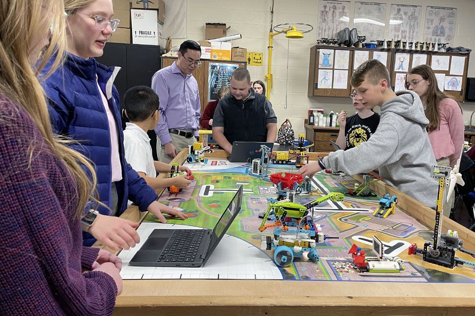 a group of kids are playing with lego robots in a room with a sign that says fragile