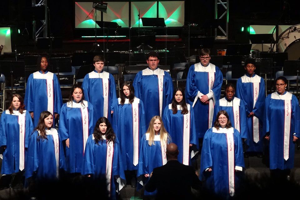 a choir wearing blue and white robes with ODCS on them